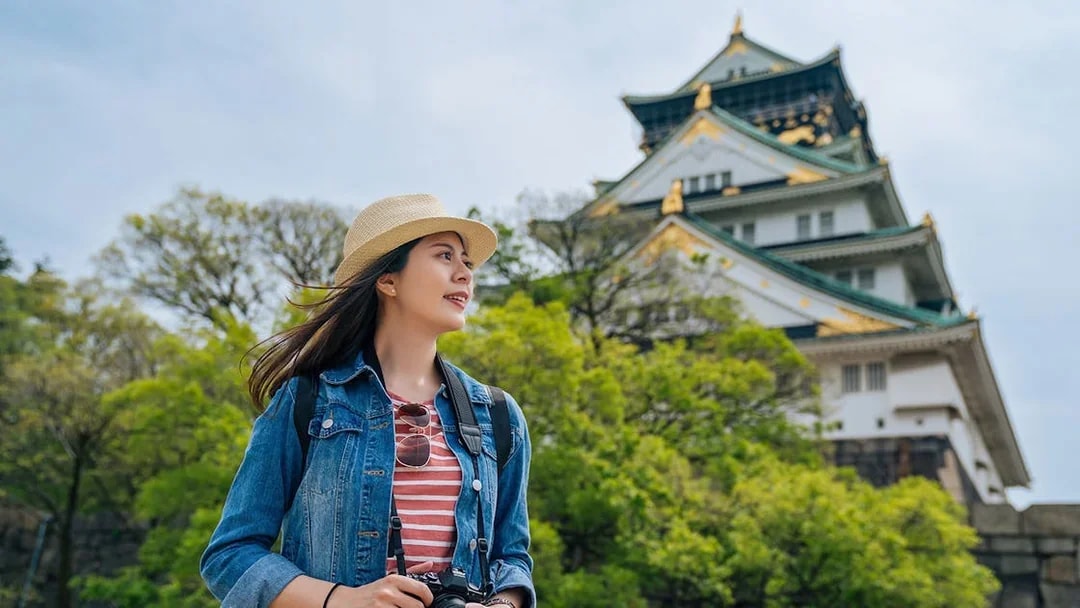 Traveler with camera near Osaka Castle, Japan.