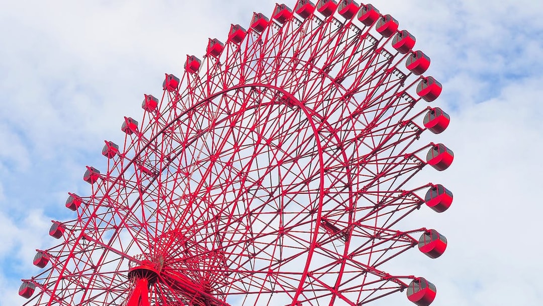 Red Ferris wheel against a blue sky, HEP Ferris Wheel Ticket.