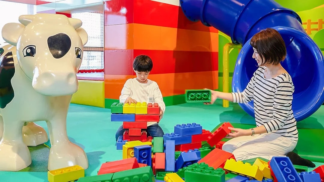 Child and adult building with large LEGO bricks at LEGOLAND Discovery Center Osaka.
