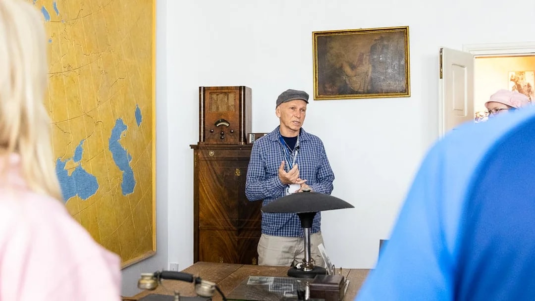 Tour guide explaining historical artifacts at Oskar Schindler's desk in Schindler's Factory, Krakow.
