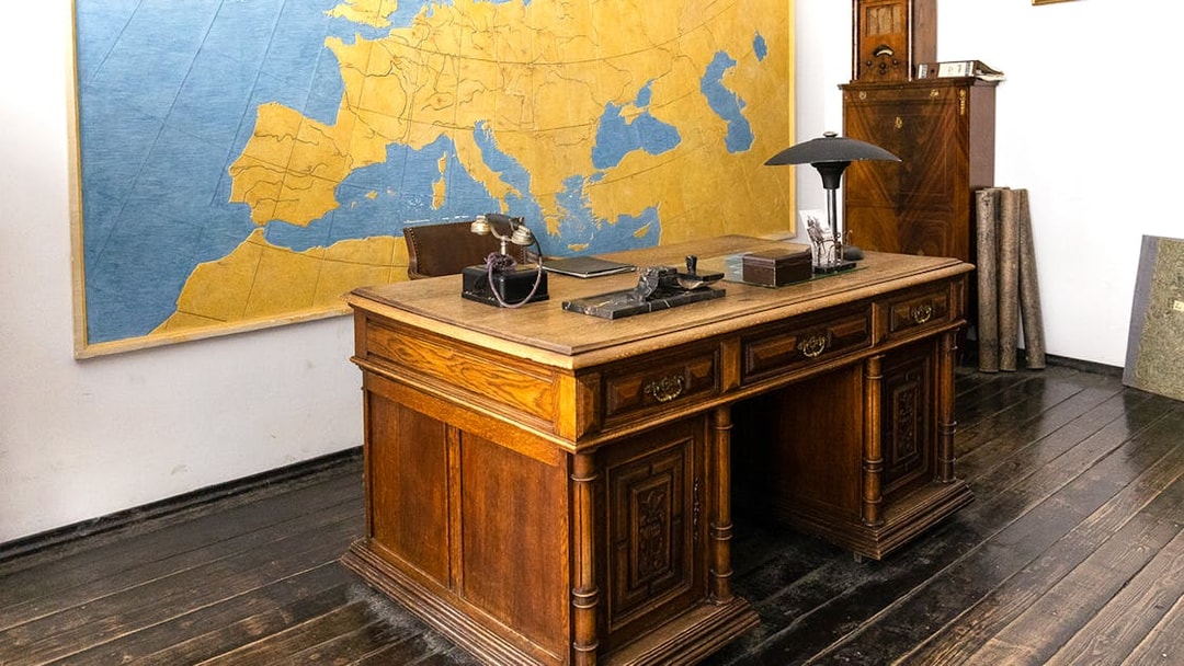 Oskar Schindler's vintage desk and chair in Schindler's Factory, Krakow, with a large map on the wall.