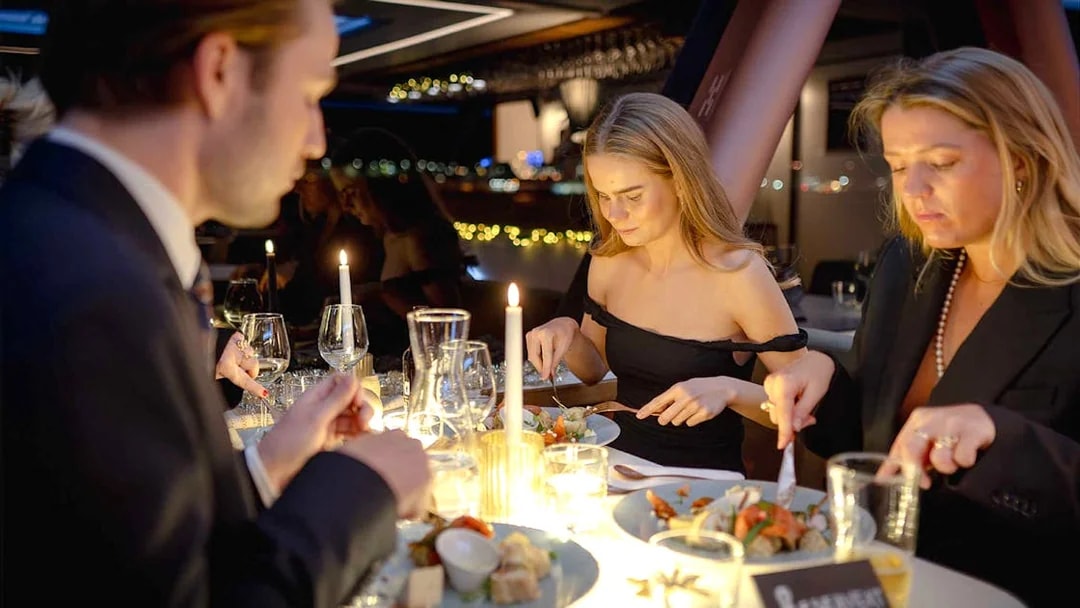 Guests dining by candlelight on an Oslo dinner cruise.