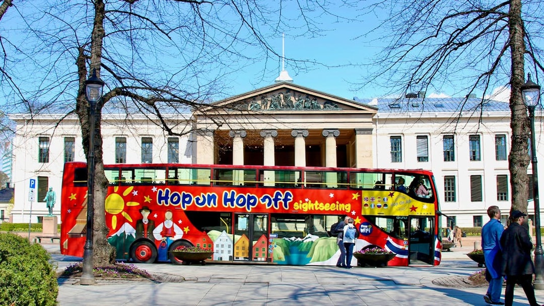 Hop on hop off bus in front of University of Oslo building.