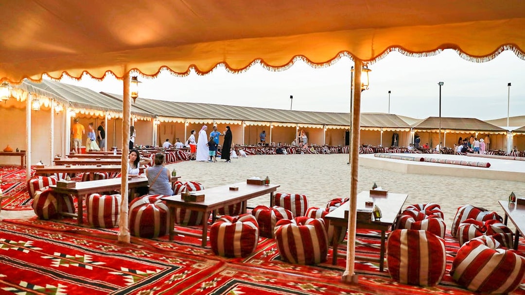 Desert camp setup with traditional seating for Bedouin safari experience.