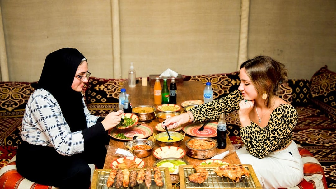 Dining experience during Bedouin desert safari with traditional Middle Eastern dishes.