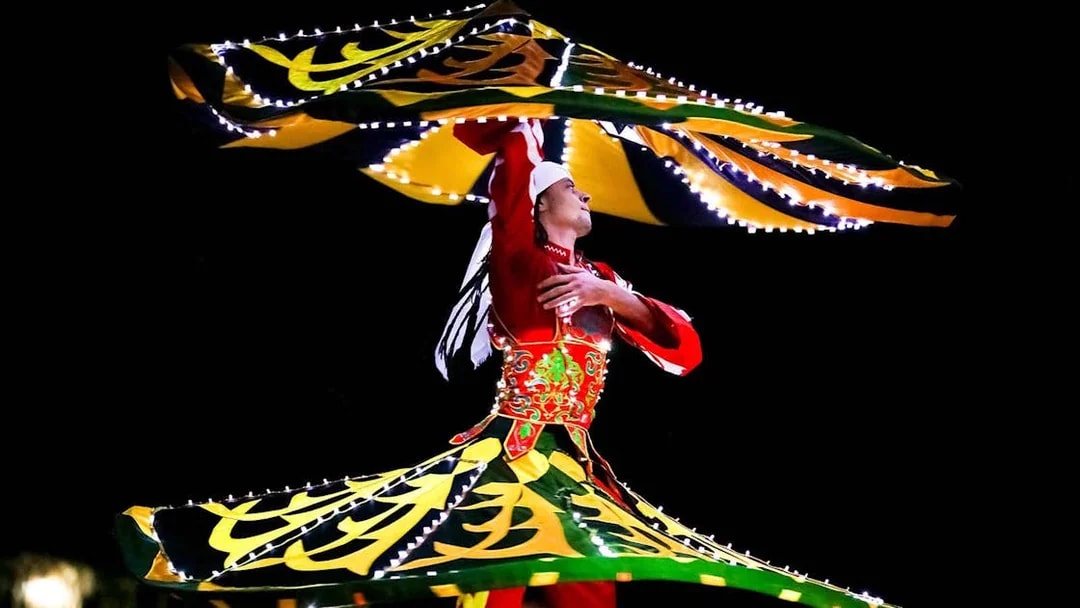 Bedouin dancer performing traditional Tanoura dance during desert safari.