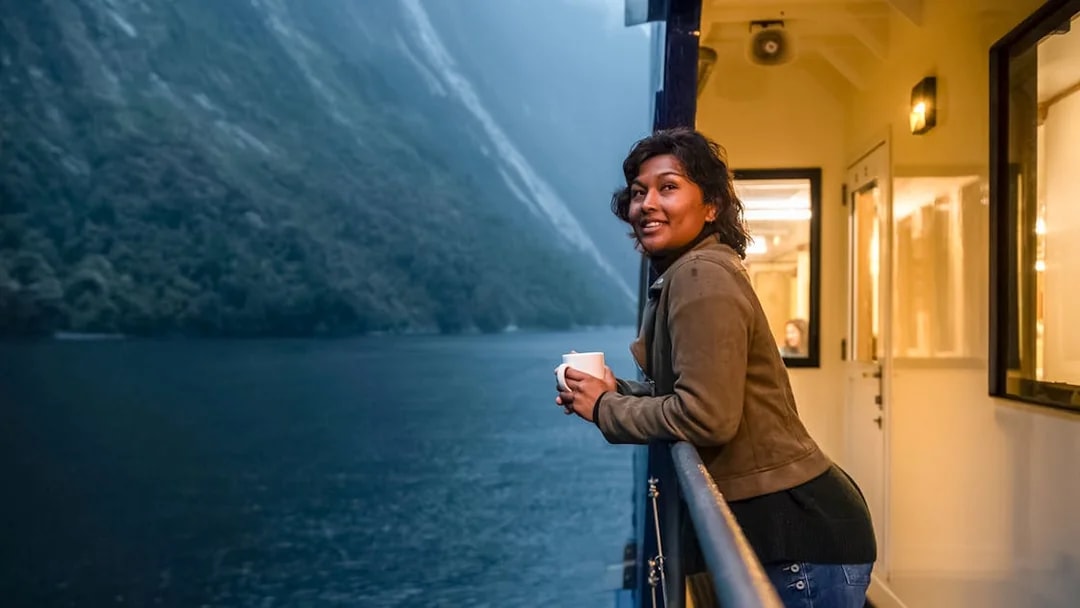 Person enjoying view from Milford Sound cruise deck.