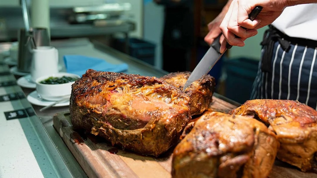 Carving roast beef on Overnight Milford Sound Cruise dining experience.