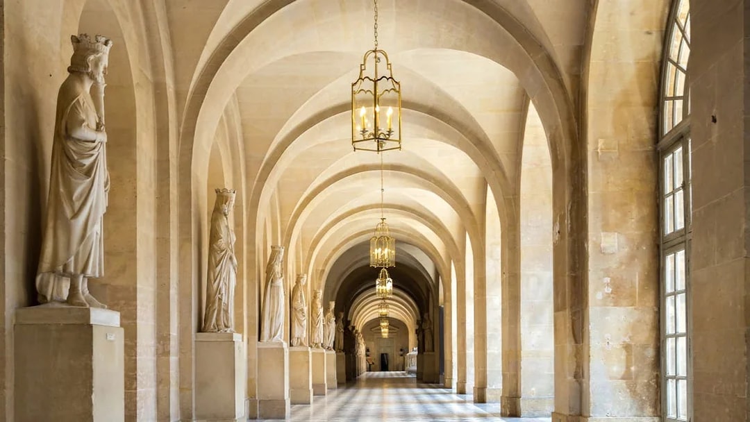 Corridor with statues and arches in Versailles Palace, France.