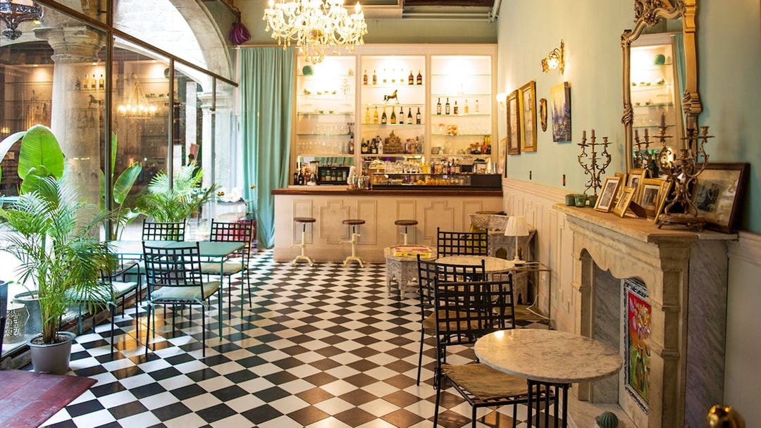 Palau Dalmases bar area with checkered floor and elegant decor, Barcelona.