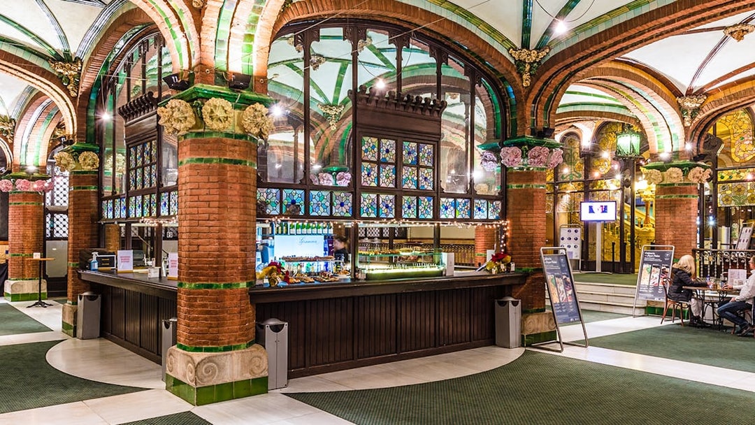Palau de la Musica Catalana counter area with stained glass and brick arches.
