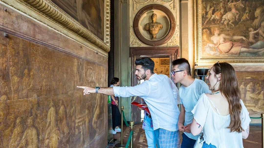 Guided group exploring frescoes in Palazzo Vecchio Museum, Florence.