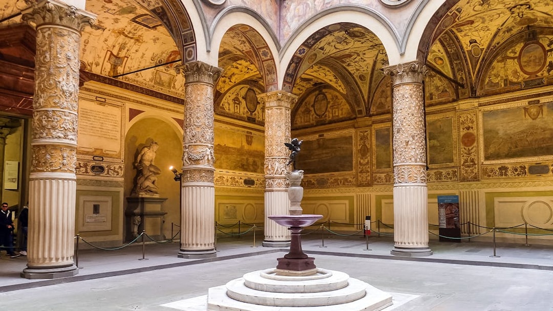 Courtyard of the Palazzo Vecchio with ornate columns and a central fountain in Florence, Italy.