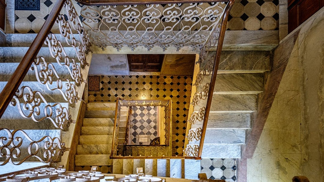 Palazzo Vecchio marble stairs with ornate railing and geometric floor tiles.