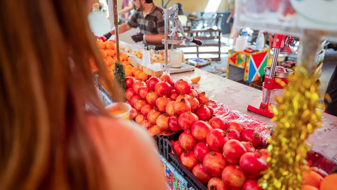 Pomegranates and oranges at a market stall during a cooking class in Palermo.