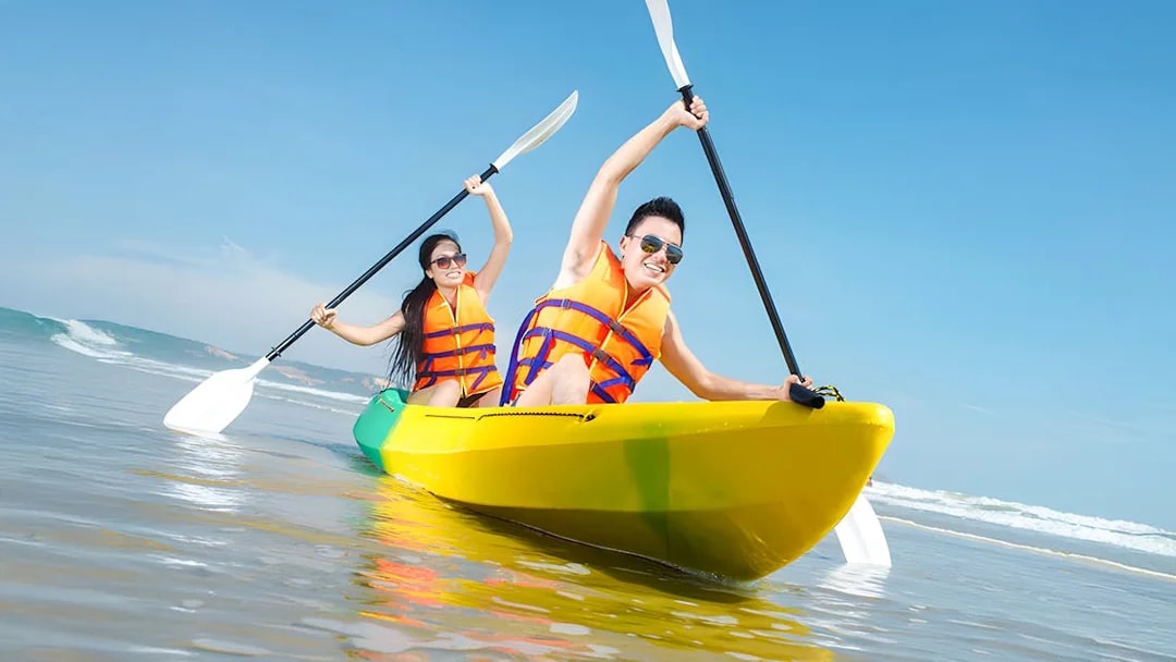 Couple kayaking in Dubai wearing life jackets.