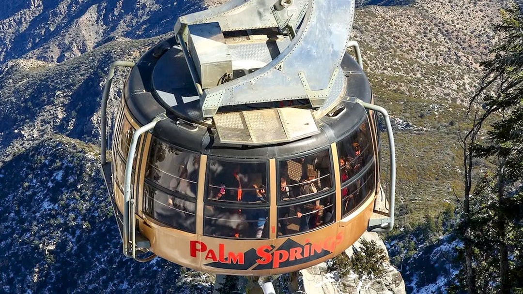 Palm Springs Aerial Tramway car ascending over mountainous landscape.