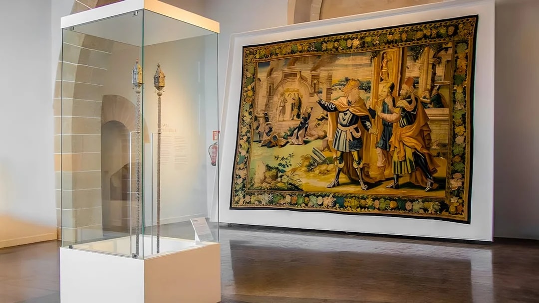 Mallorca Cathedral interior with historical tapestry and artifact display.