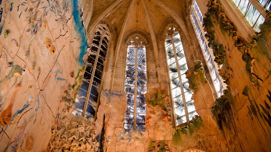 Mallorca Cathedral interior with intricate stained glass windows and detailed wall carvings.