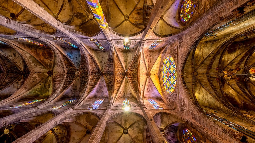 Ceiling view of Santa Maria de Majorica's gothic cathedral in Palma with stained glass windows.