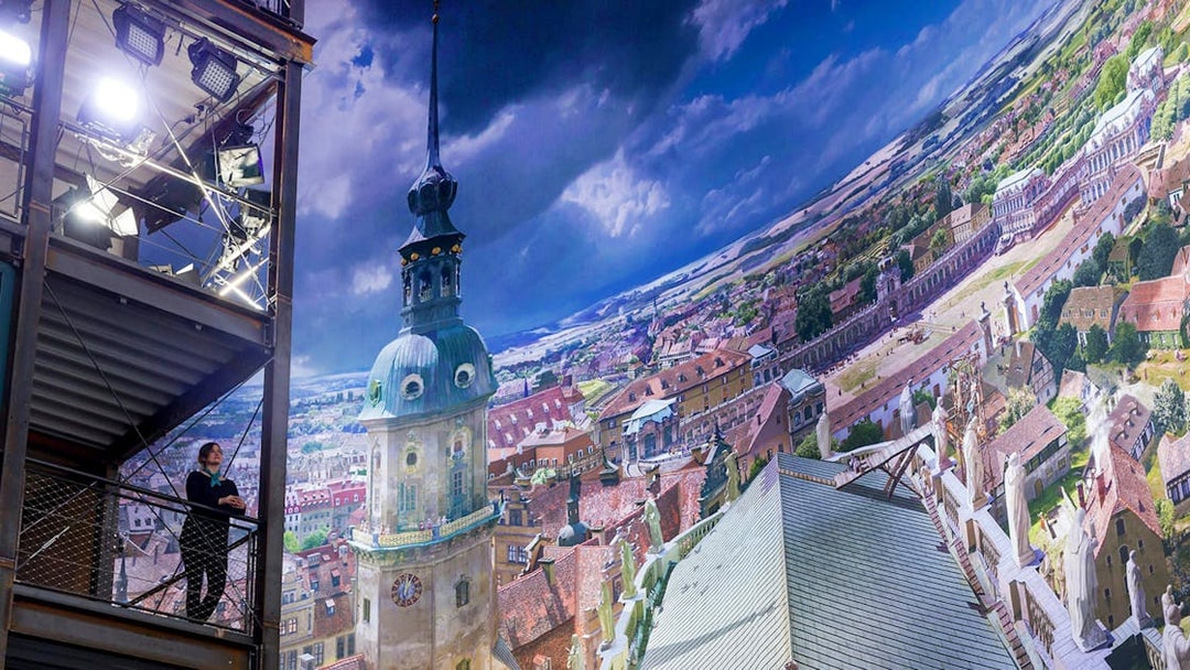 Panometer Dresden interior with panoramic cityscape and visitor on viewing platform.