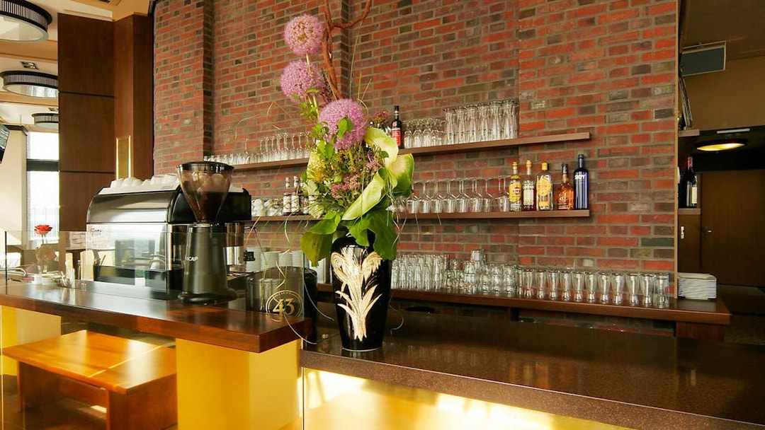 Bar area at Panoramapunkt Berlin with coffee machine and floral arrangement.