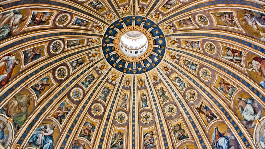 St. Peter's Basilica dome interior with intricate frescoes and gold detailing, Vatican City.