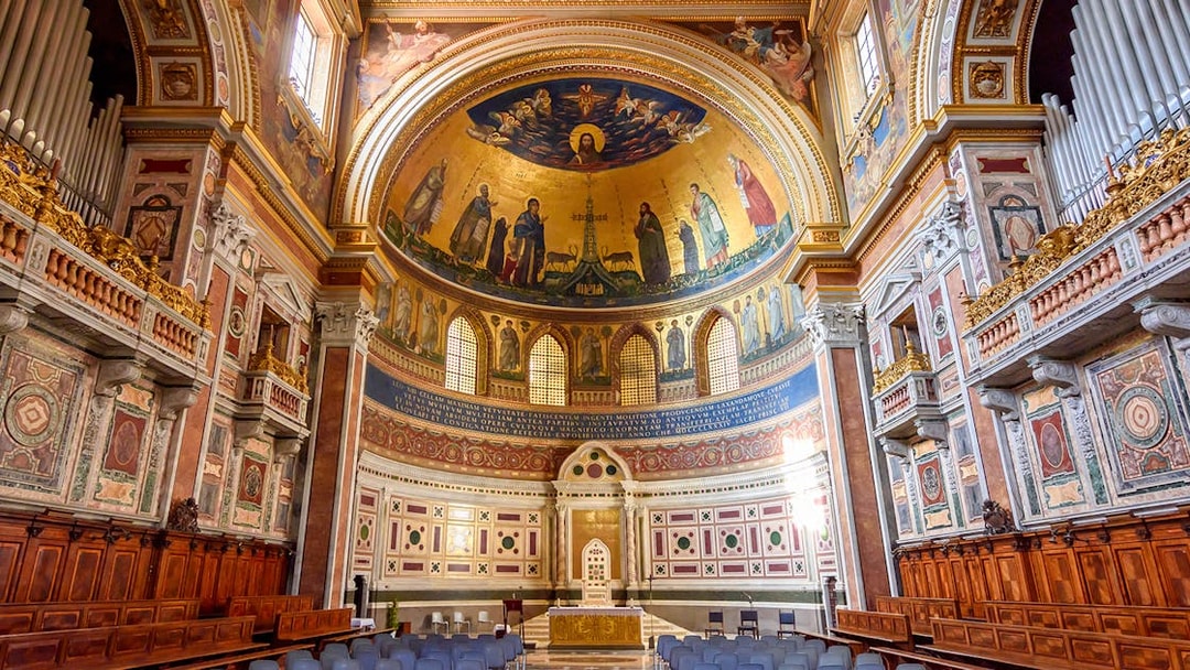 Interior of a Roman basilica with ornate frescoes and arches on the Appian Way tour.