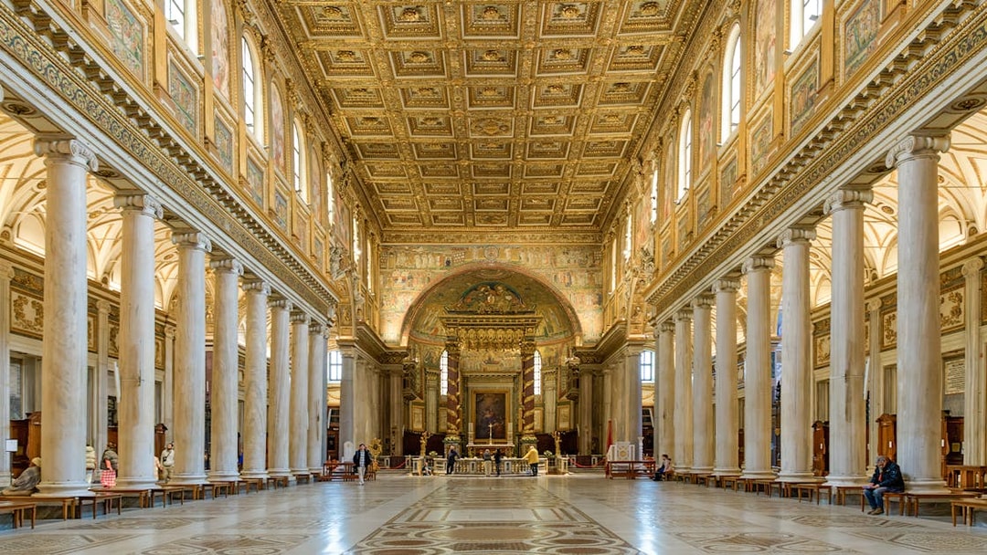 Interior of a Roman basilica with ornate ceiling and columns on the Appian Way tour.