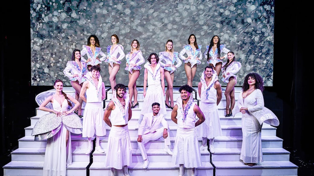 Cabaret performers in white costumes on stage in Paris for "My First Cabaret" show.