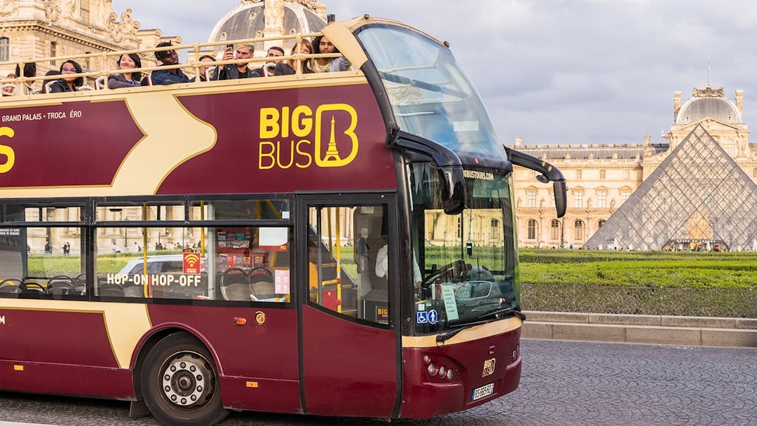 Tourists on Big Bus tour near the Louvre Pyramid in Paris.