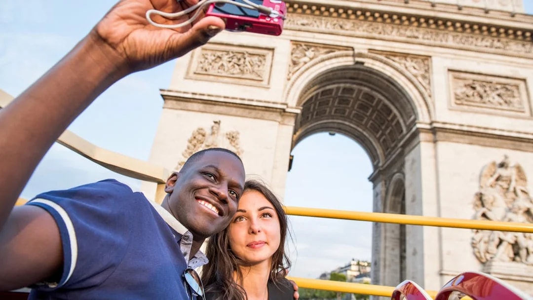 Tourists enjoying the Big Bus Paris Hop-On Hop-Off Bus Tour with a view of the Eiffel Tower and Seine River in the background