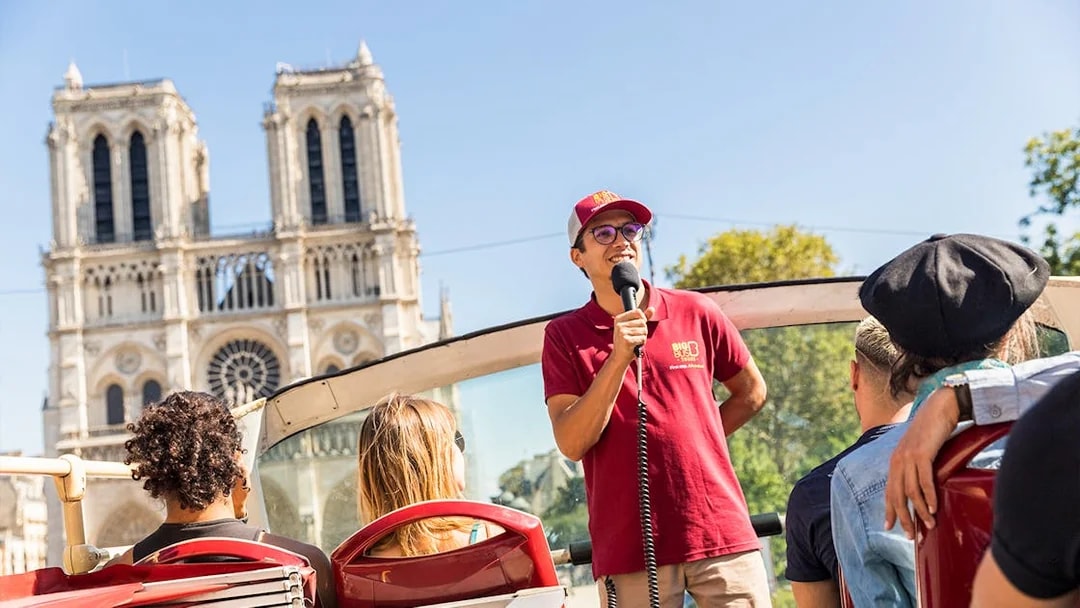 Tour guide speaking on Big Bus near Notre-Dame Cathedral, Paris.