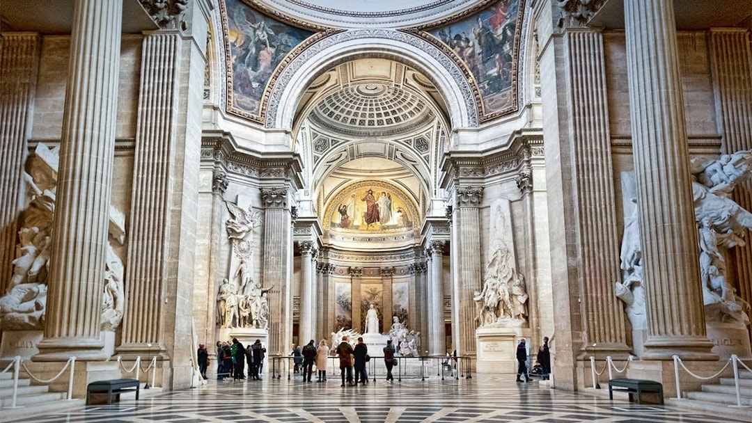 Interior of the Paris Pantheon with ornate columns and detailed sculptures.