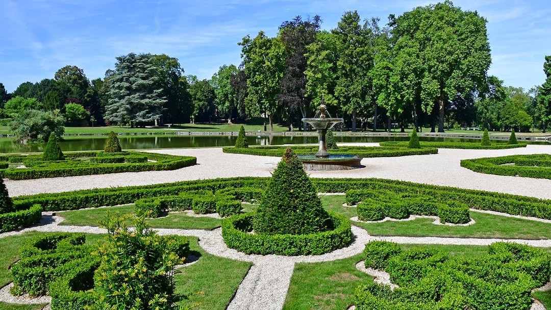 Fountain and manicured hedges in the Garden of Castle Chantilly, France.