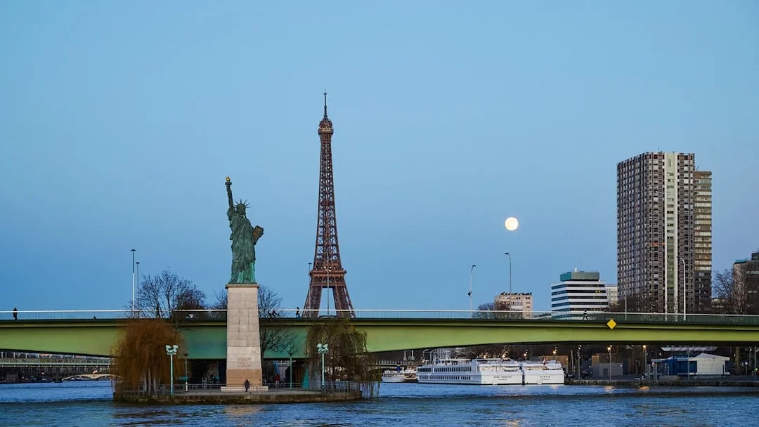 Eiffel Tower and Statue of Liberty from Seine River cruise in Paris.