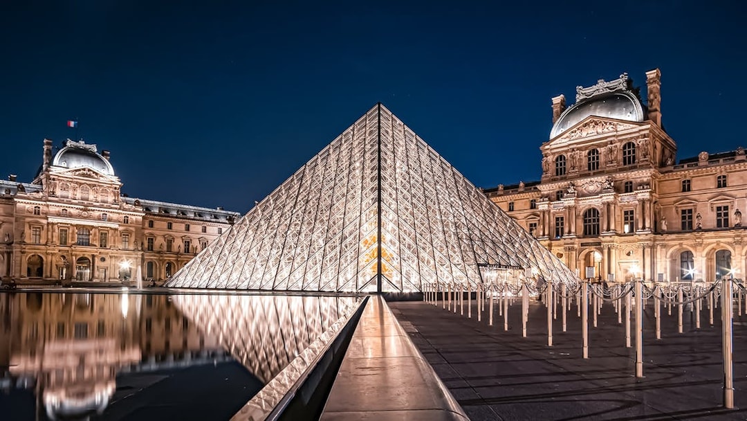 Louvre Pyramid illuminated at night in Paris, France.