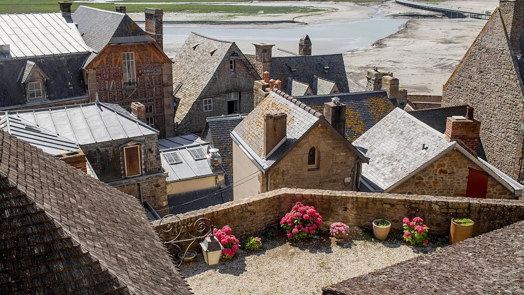 Slate-roofed houses in Mont Saint-Michel with a view of the tidal flats.