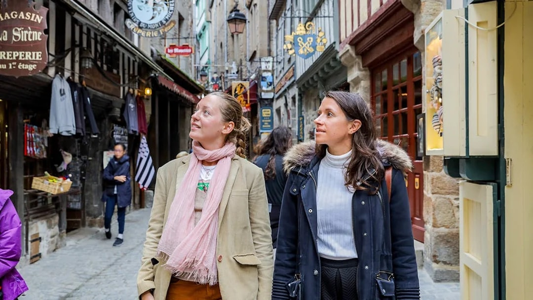 Visitors exploring the narrow streets of Mont Saint-Michel on a guided tour.