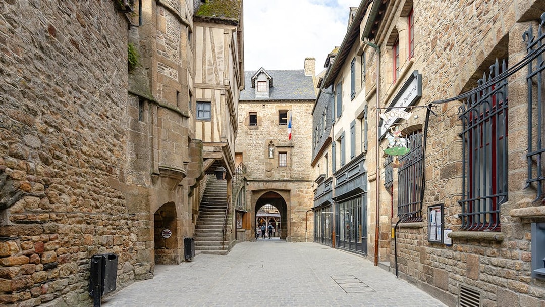 Mont Saint Michel narrow cobblestone street with historic stone buildings.