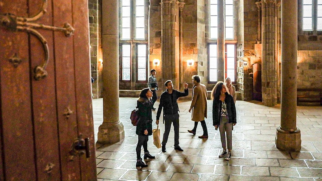 Visitors with a guide exploring the interior of Mont Saint-Michel Abbey.