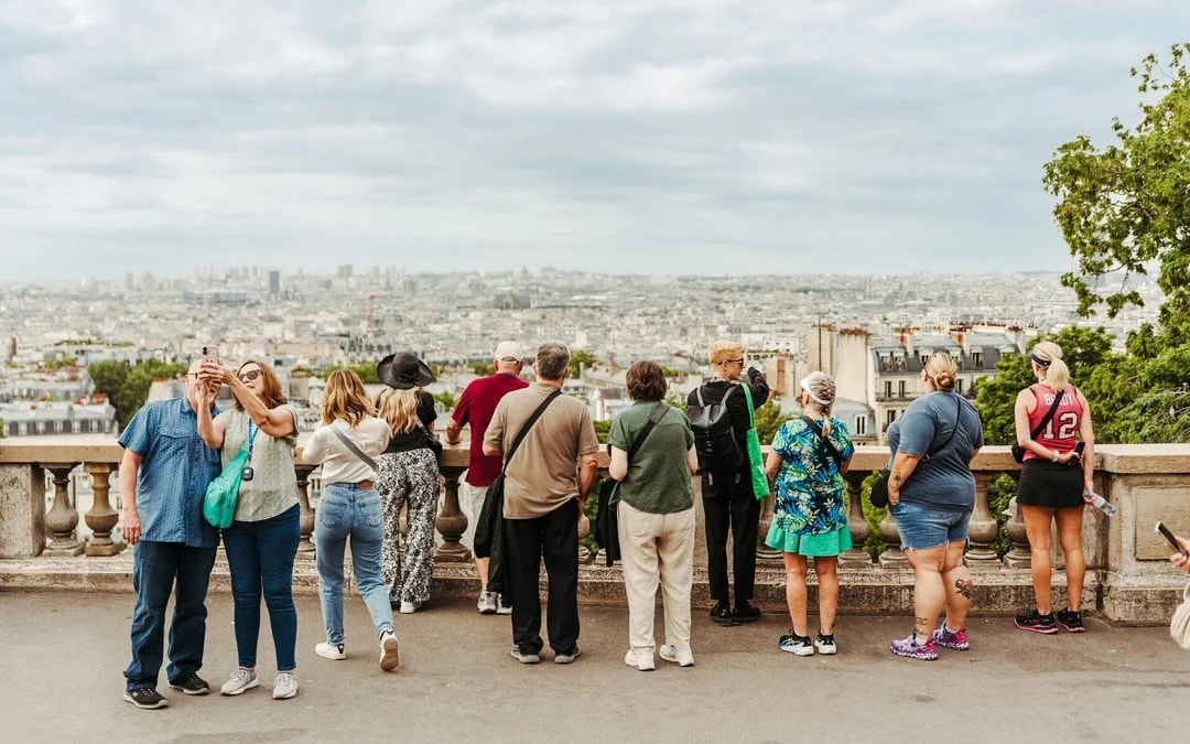 Tourists enjoying a panoramic view of Paris from a city tour vantage point.