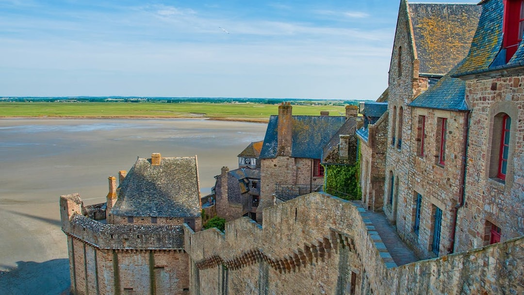 Mont St. Michel stone buildings and walls with tidal flats in the background.