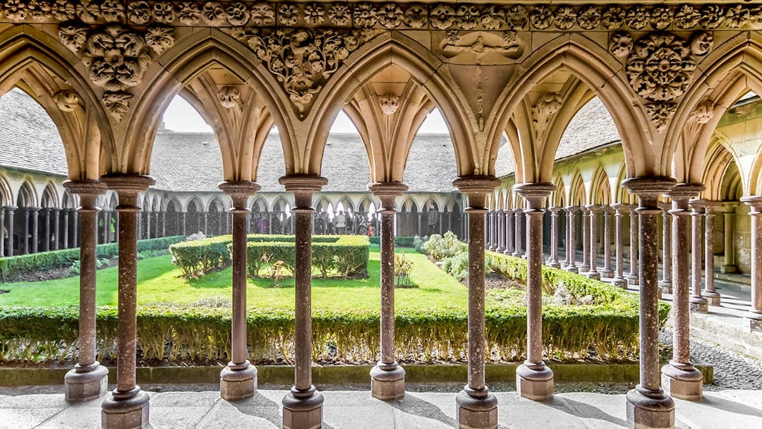 Cloister arches and garden at Mont St. Michel Abbey, France.