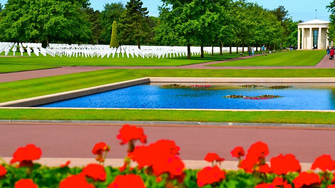 Normandy American Cemetery with rows of white crosses and reflecting pool.