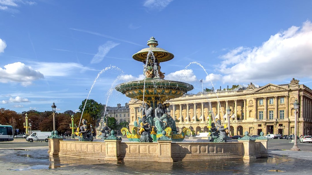 Fountain at Place de la Concorde, Paris, with historic building in background.