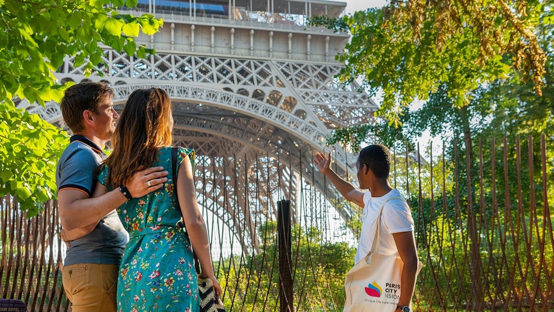 Tour guide showing visitors the Eiffel Tower's 2nd floor during Paris city tour.