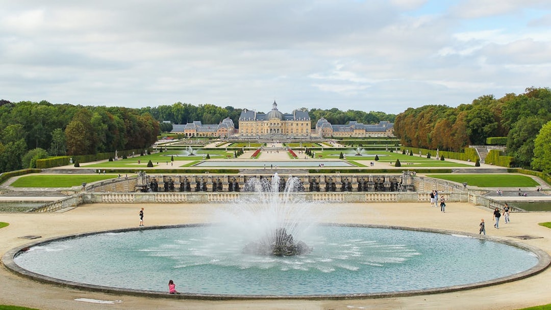 Vaux-le-Vicomte gardens with central fountain and chateau in the background, near Paris.