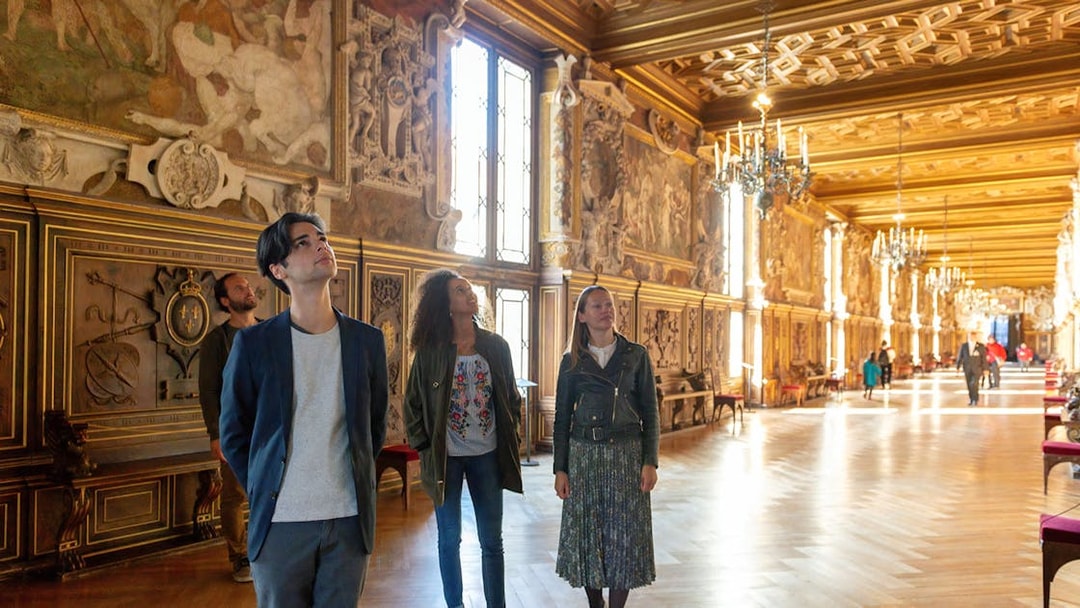 Visitors exploring ornate hall at Vaux-le-Vicomte during Paris audio-guided tour.