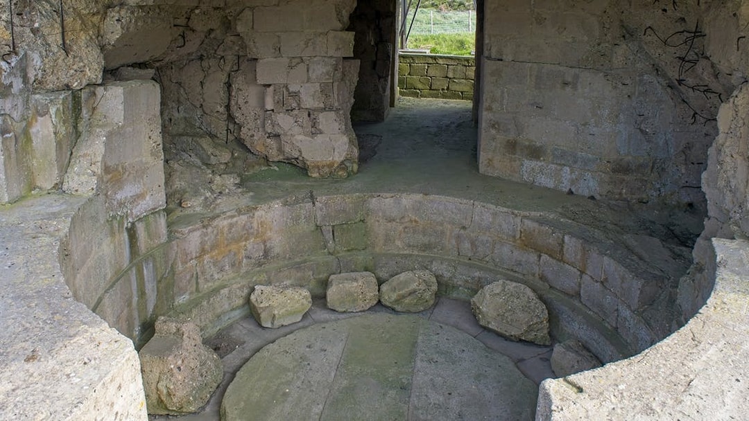 Normandy D-Day bunker interior with stone walls and circular structure.